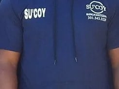 The Su’Coy mark embroidered on a crew uniform shirt